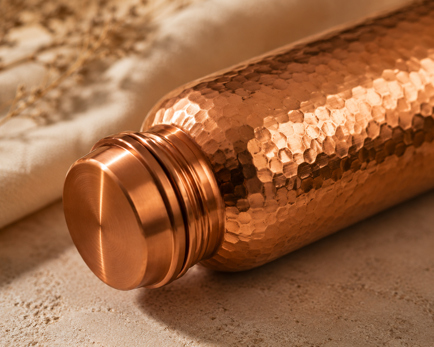 Macro detail of The Ritual Bottle's hammered copper texture and threaded cap.