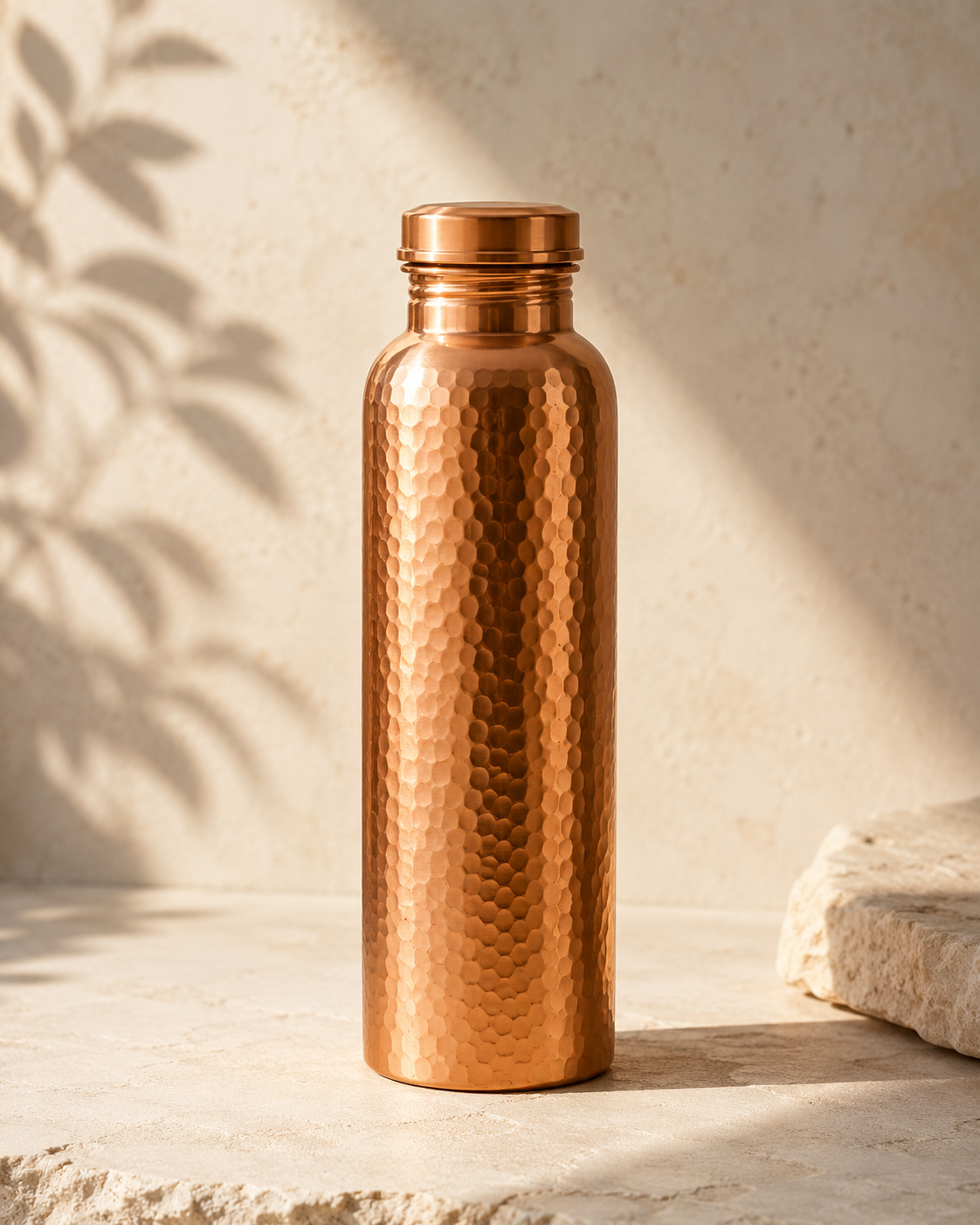 The Ritual Bottle on a sunlit stone ledge with leaf-shadow, a clean studio hero shot.